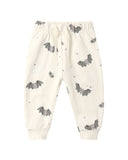 Off-white jogger pants with an all-over bat print, featuring an elastic waistband with a drawstring and ribbed ankle cuffs.